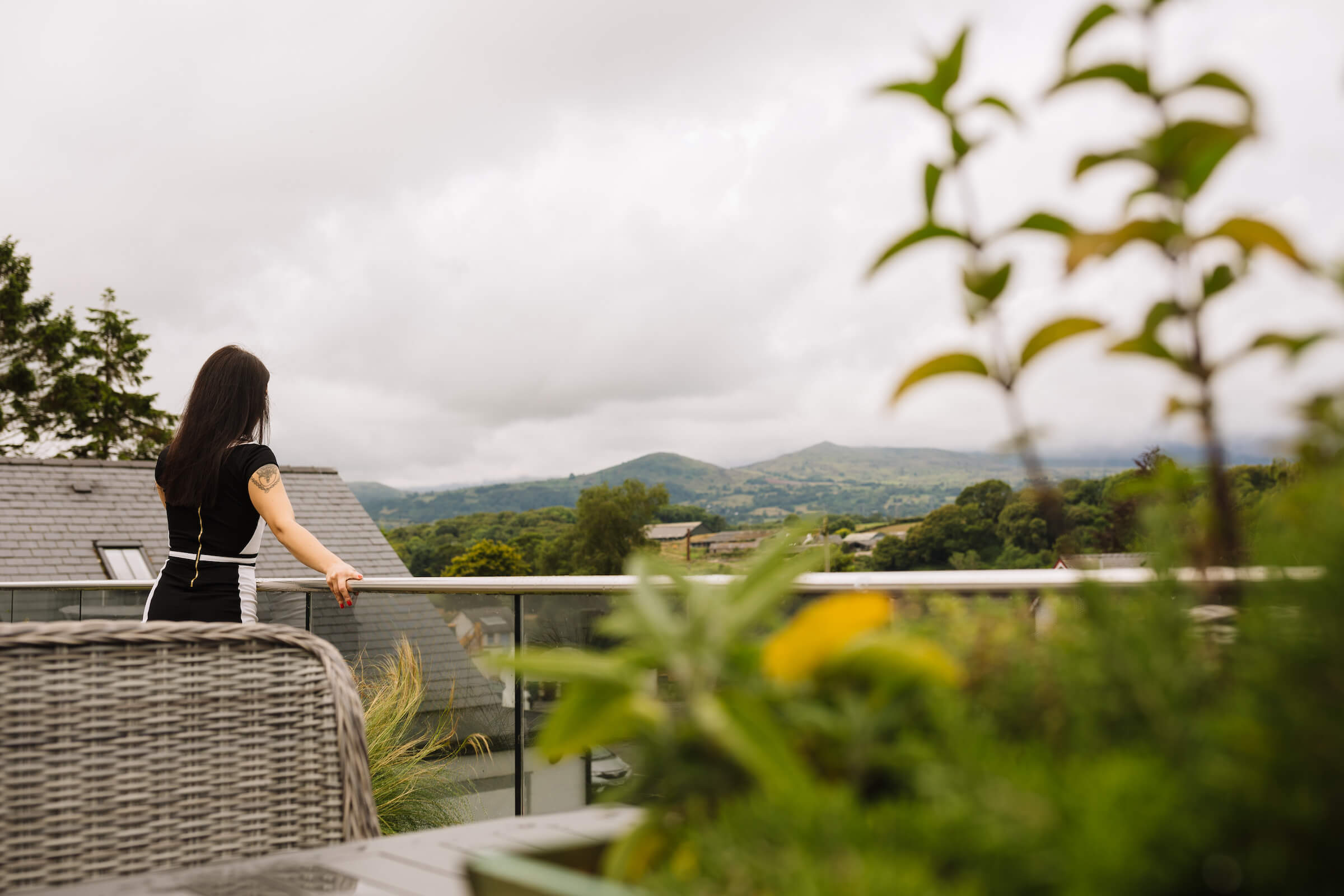 Woman on outdoor terrace looking at distant hills